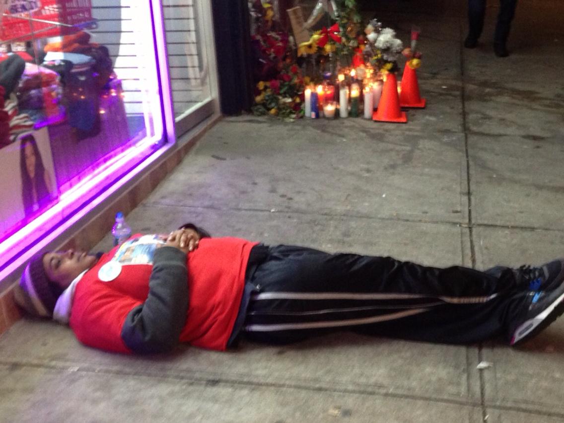 peterhaskell880's tweet photo. W/ memorial in background, #EricGarner's daughter Erica, lies on sidewalk where dad died.  @wcbs880 http://t.co/r0BYI82Fip