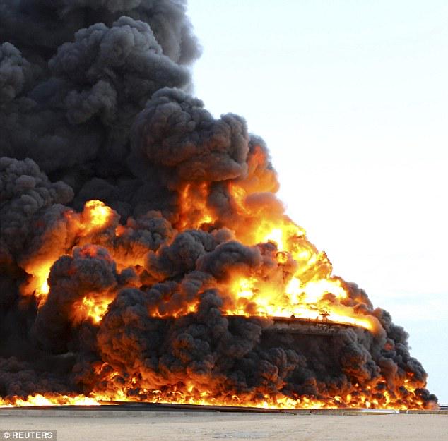 DailyMail's tweet photo. Libya's largest oil port on fire after rebels launch rocket strikes http://t.co/eN0Hnx5QqB http://t.co/edmD1M0gmb