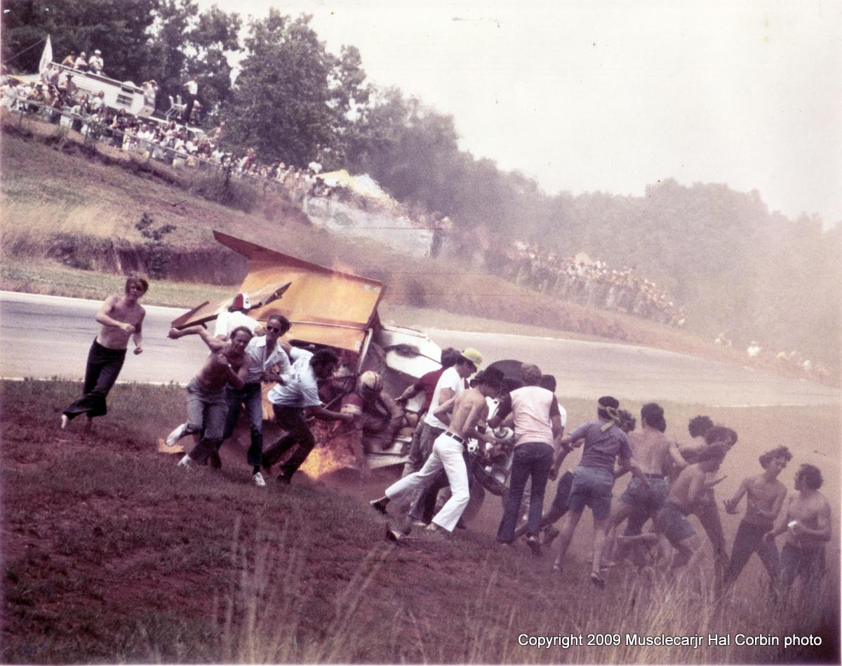 MuscleCarJr's tweet image. 1972 Mclaren Can Am Crash @ Road Atlanta photo by Hal Corbin. Fans are helping Denny out of the car that is on fire