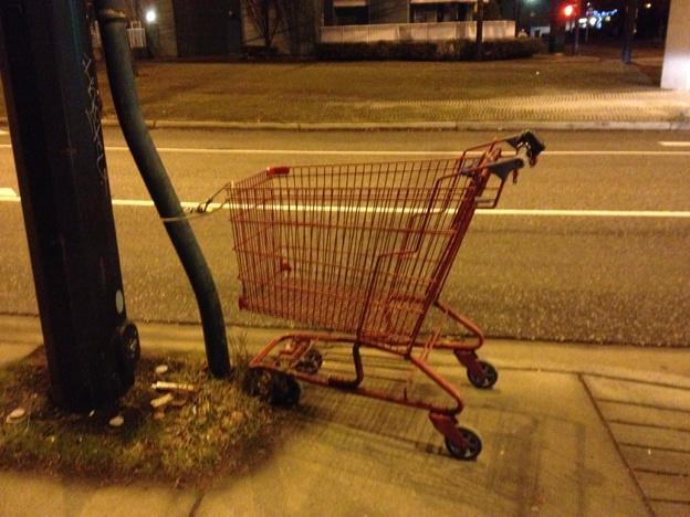 A shopping cart locked to a post with a bicycle lock. #OnlyInVancouver