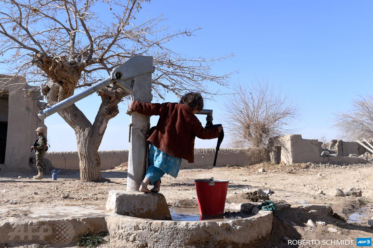 afpfr's tweet image. #instantané Une jeune fille joue avec pompe à eau à Sangesar en #Afghanistan  #AFP [via @sbeaugeAFP]