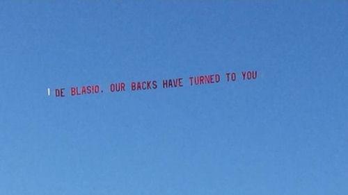 NYPD sky banner DeBlasio Our backs have turned to you 