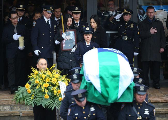 nytchinese's tweet photo. 【纽约华裔警官葬礼上的无声抗议】纽约市长在葬礼上高度评价了遇难警察刘文健，称他从中国来到纽约，追随自己的梦想加入了警察局，是“勇敢”而“善良”的纽约人的典范。http://t.co/FyvKcxS0lH http://t.co/kXEE2L96E8