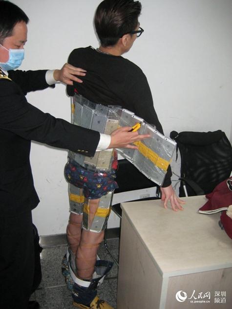 SomosBoom's tweet photo. Brutal imagen: La policía de aduanas china arresta a un hombre con 94 iphones pegados al cuerpo http://t.co/rvHIoZdW0m