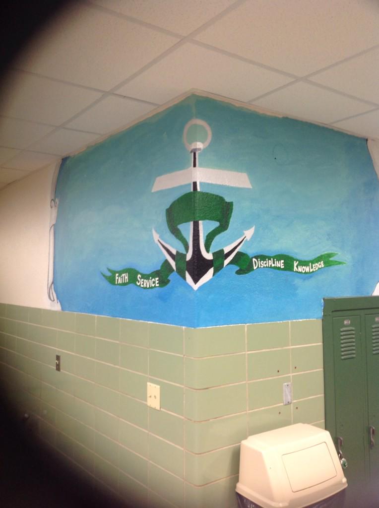 A mural painted by students that contain an anchor that contains a cross, found up the middle staircase