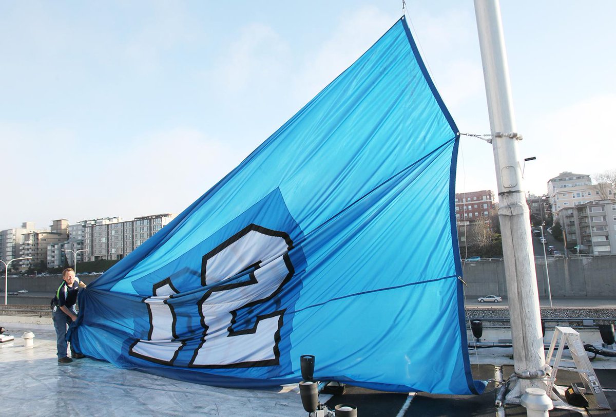 PSBJphoto's tweet photo. My lens, @PSBJ photos:  @PEMCO raises huge #12man flag on their rooftop in final #BlueFriday for #SeattleSeahawks http://t.co/dHIOScxDtr