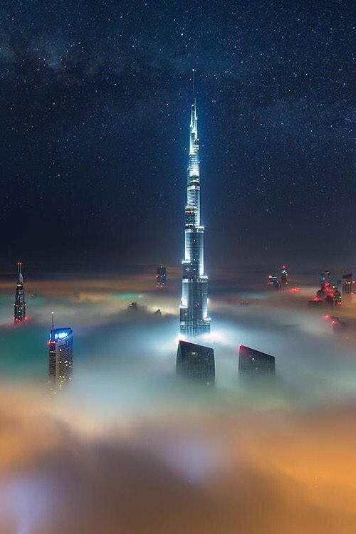 Dubai at night above the clouds