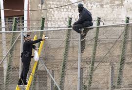guardiacivil's tweet photo. Lo que algunos no quieren ver...Un Guardia Civil subido a la valla de #Melilla para dar un bocadillo a un inmigrante http://t.co/2Yh2563qiB