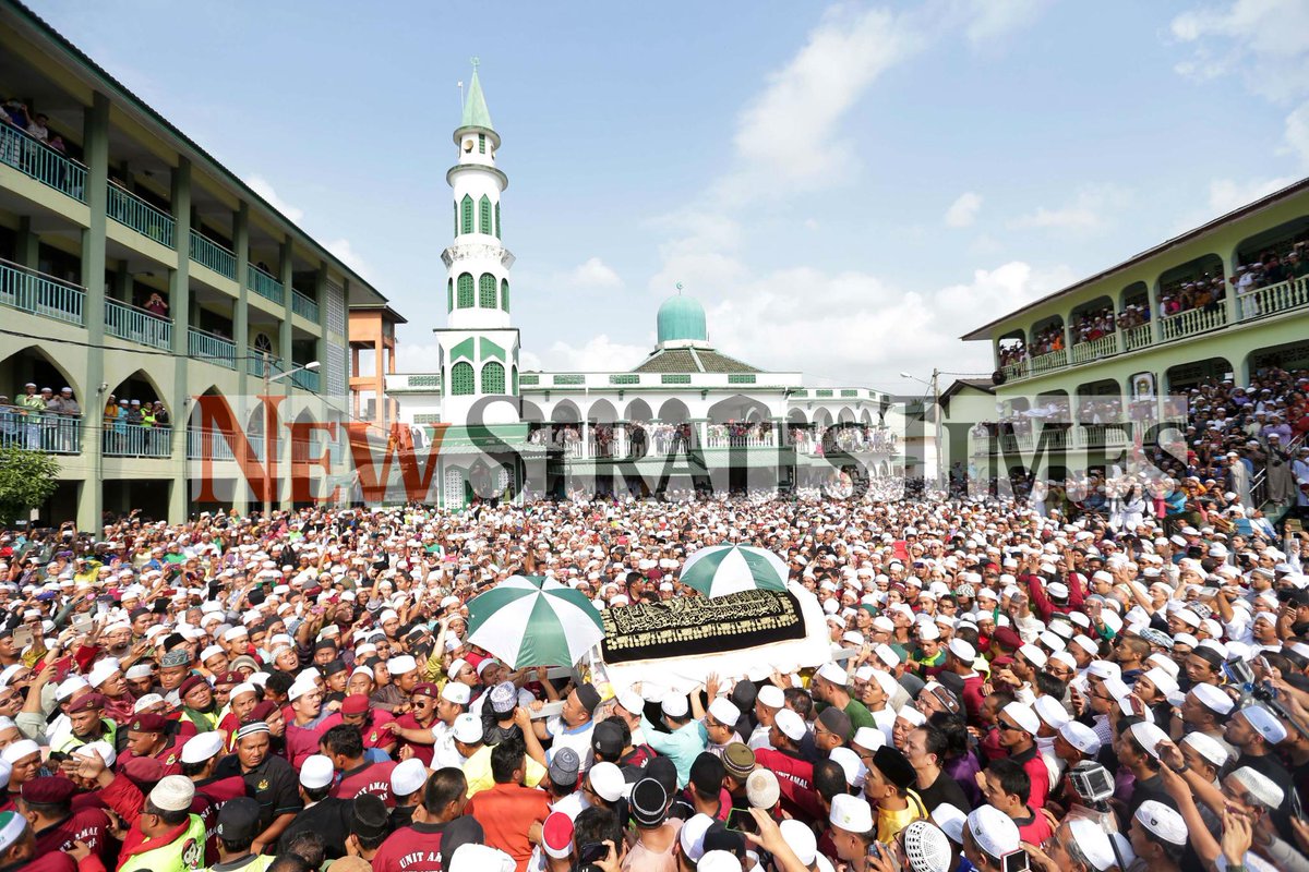 NST_Online's tweet photo. Coffin carrying the body of #NikAziz carried past a crowd shouting "Allah HuAkbar" frm his house to the burial site http://t.co/N8P7KDoa5d