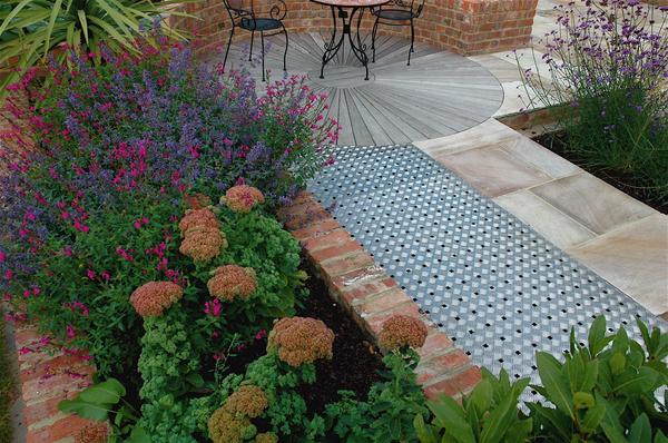 Stainless steel (underlit) walkway links circular deck with house, hardscaping doesn't always need to be paving.