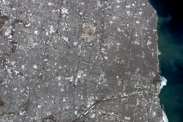 Cmdr_Hadfield's tweet photo. Chicago on a clear winter's day, ice on the shore, busy O'Hare airport visible from orbit. http://t.co/wICzMP7kKA