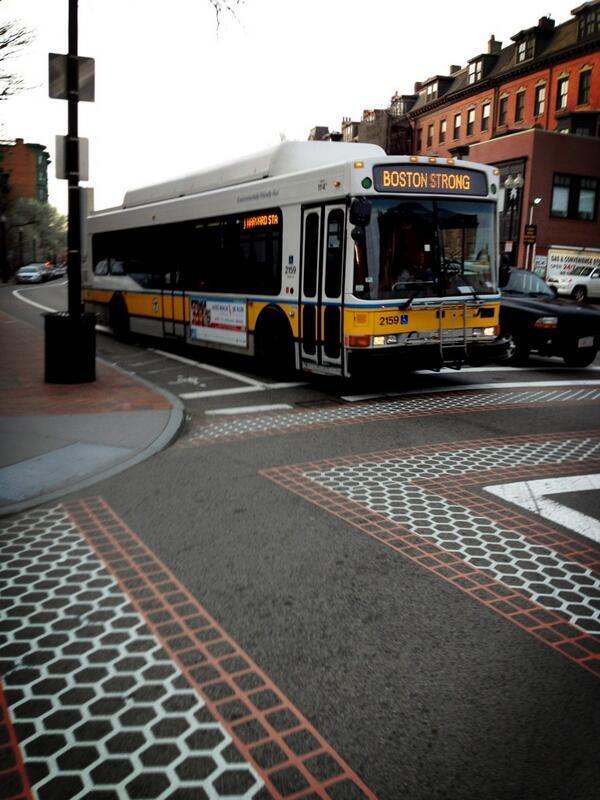 A bus going through South Boston proudly displays 'Boston Strong' on its head sign and side LED sign.