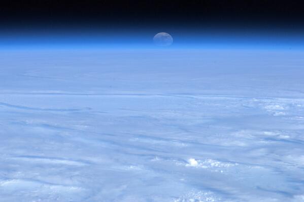 Tonight's Finale: Distorted by the lens of the Earth's atmosphere, the Moon rises over a bed of cloud.
