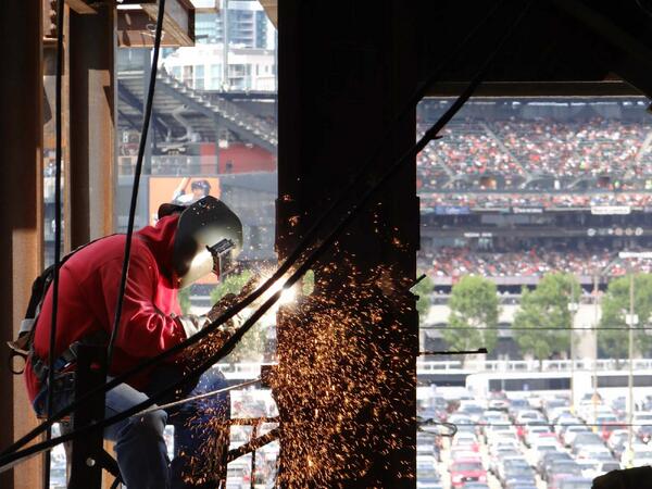 sfpublicworks's tweet photo. A welder works on the new Public Safety Building while the @SFGiants play the Phillies in the background http://t.co/LuSydvWngn