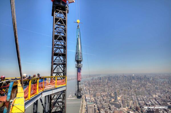 _WTCOfficial's tweet photo. Ironworkers at #OneWTC look on as the final flag-draped section of spire is hoisted to the top of the building. http://t.co/NFP9XzpG6r