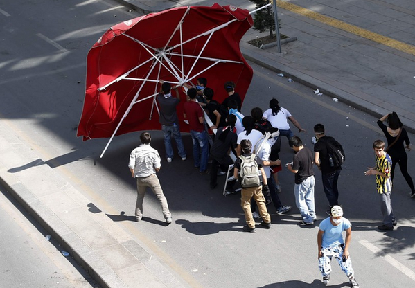 Big umbrella becomes makeshift shield in #Ankara clashes. Latest <a href="/Reuters/">Reuters</a> photos: bit.ly/18HBrLN