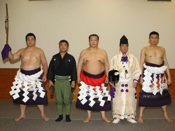 還暦を祝う会＞還暦を意味する赤い綱を締めた北の湖理事長を中心に記念
