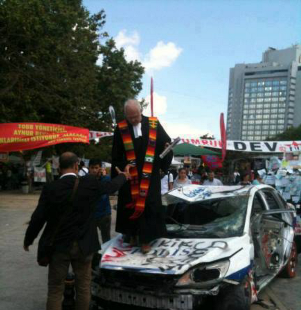 Taksim'de yakılan polis otosunun üstünde bir papaz. Bu nasıl kirli bir oyundur