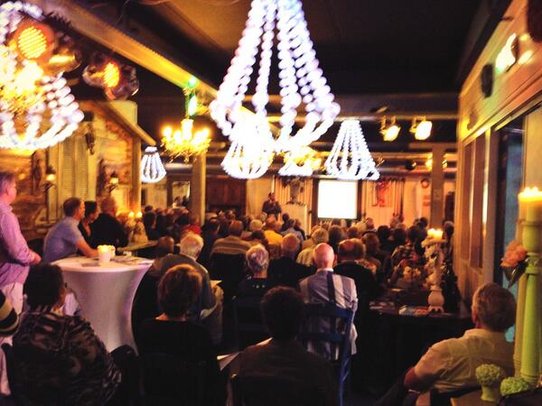 Gasten luisteren naar John Kroes.  Zij willen hun financiële toekomst voor hun (klein)kinderen veilig stellen! #AWBZ