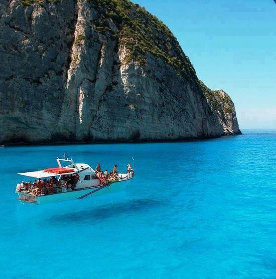 WhatTheFFacts's tweet photo. An island in Greece named Zakynthos is surrounded by crystal clear water, it looks like the boat is floating in air. http://t.co/5wDteWdnw8