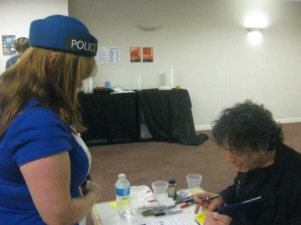 GroovyVicks's tweet photo. Pic of @neilhimself being presented with a TARDIS Air in-flight safety card! He seemed to approve! http://t.co/yCnNeAZF9D