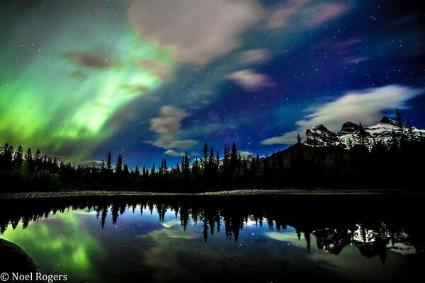 The Northern Lights (Aurora Borealis) over The Three Sisters in Canmore, Alberta.