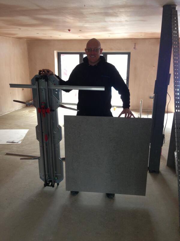 TilingChris's tweet image. Me and my new toy (cheers @StuartRUBI_Rep) with the metre square tiles we started laying today