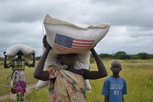 Best flying of a U.S. flag: A woman carries a bag of food in Gumuruk where @WFP is assisting IDPs uprooted by violence.