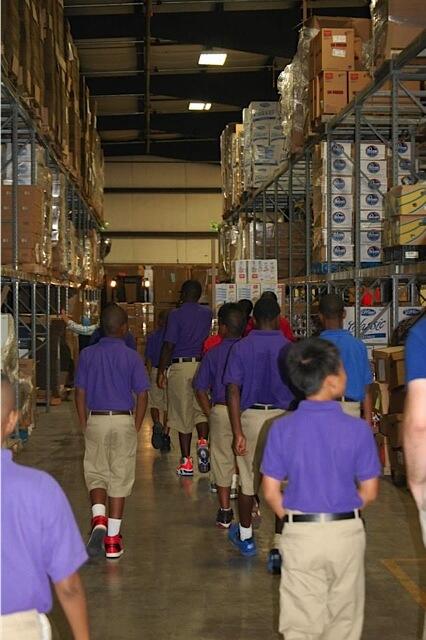 West End School boys visit Dare to Care and help prepare backpacks for children.