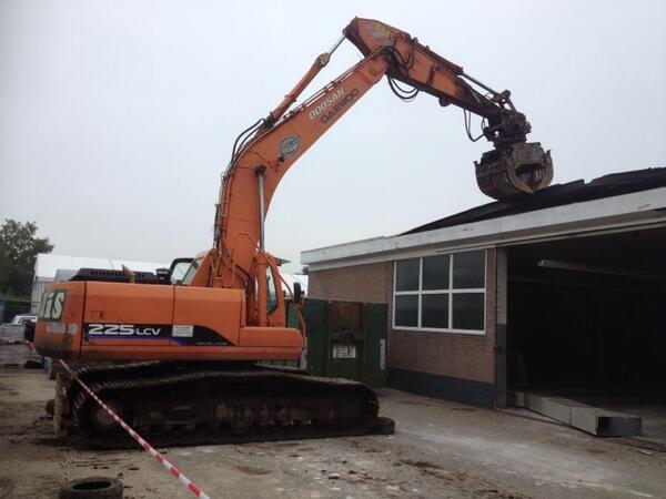 Uit het dak bij Autohuis Eickhof, het dak gaat eraf.