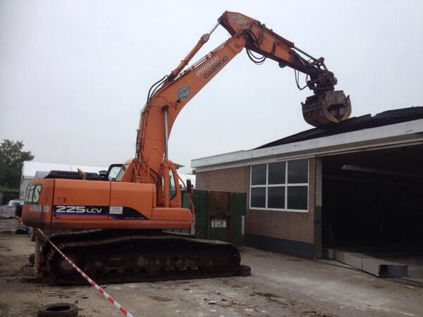 Uit het dak bij Autohuis Eickhof, het dak gaat eraf.