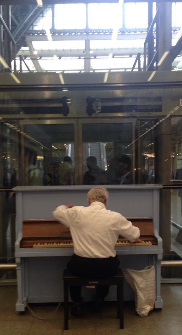 Old man tearing up one of the pianos at st. Pancras
