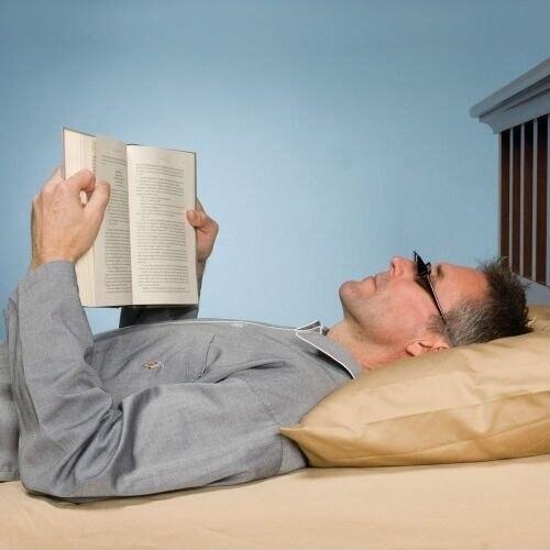 Читать лежа вредно лежа на горячем песке. Чтение лежа. Мужчина лежит читает. Человек читает лежа. Читать лежа.