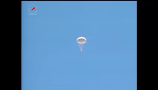 NASA's tweet image. A first view of the #Exp37 crew descending under its parachute. Temps are below freezing at the landing site. 