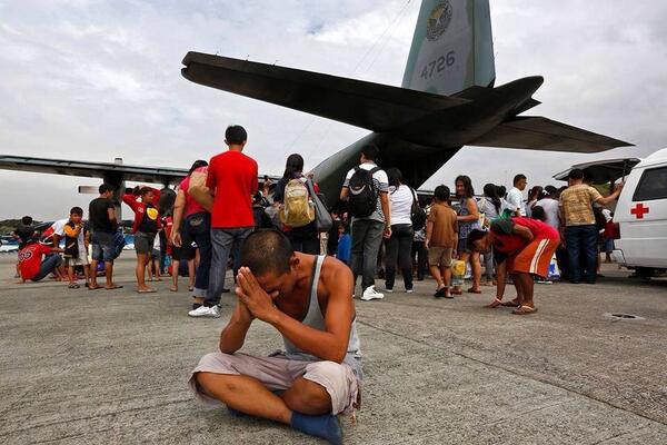 gmanews's tweet image. A man prays before getting into the PAF C130 bound for Manila from Tacloban.  | via @TeamAFP