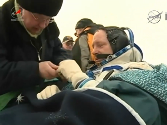 NASA's tweet image. Ground crews wrap #AstroButch in blankets to keep him warm. He completed 4 spacewalks, now has 178 days in space.