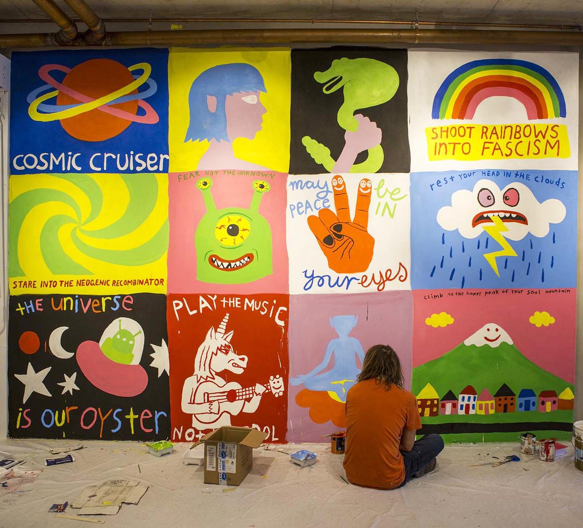 Cosmic cruiser Ozzie Wright​ sitting amongst his paintings of