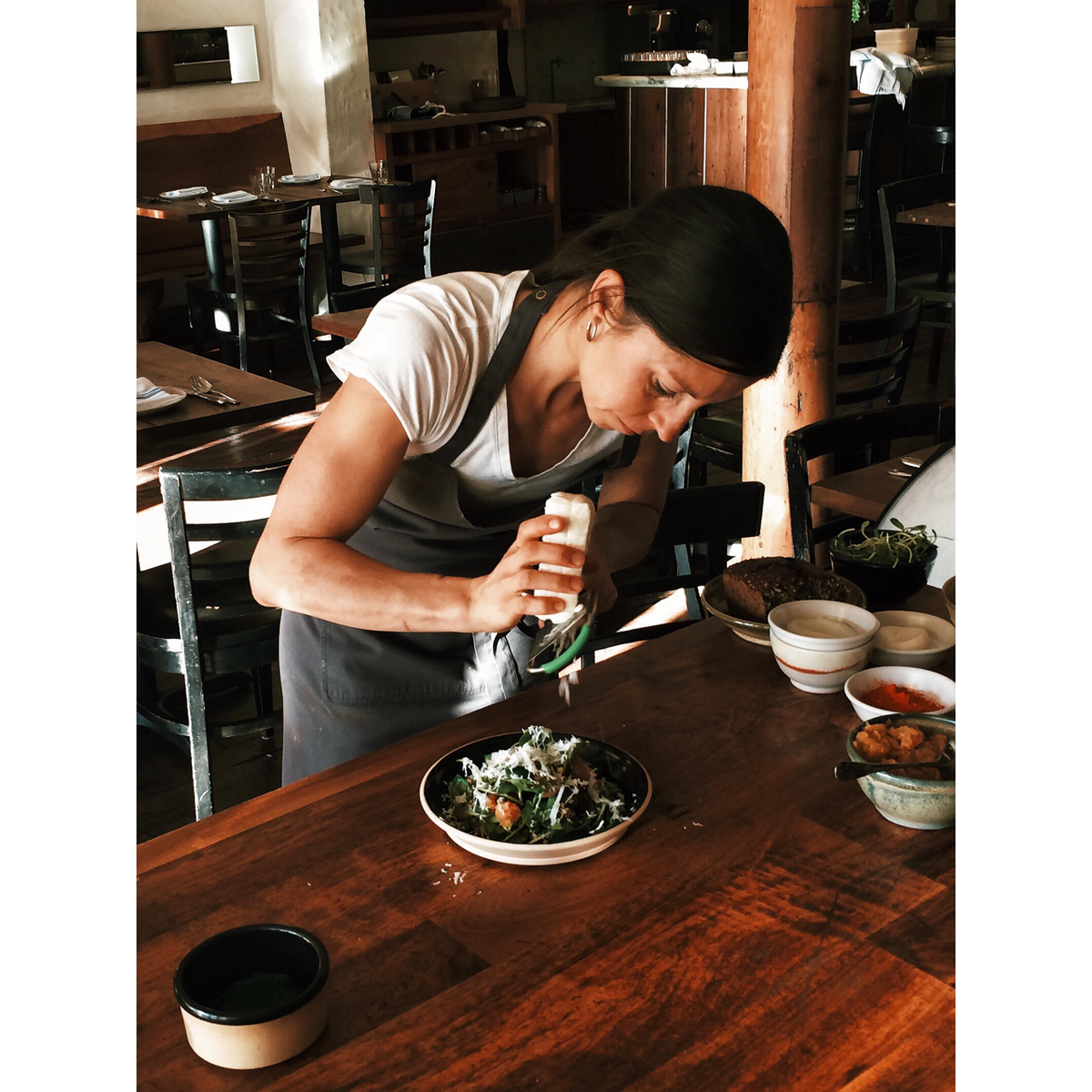 Chef Cortney Burns of <a href="/BarTartine/">Bar Tartine</a>  grating house-made feta on beet salad at our photo shoot for spring issue.