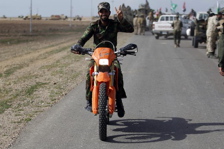 TheIraqPulse's tweet image. #Photooftheday: A #Shiite fighter riding a motorbike gestures in the town of #Hamrin, in #Salahuddin province