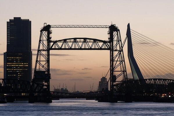 Prachtfoto van Rotterdam in avondlicht. De Rotterdam, De Hef en De Zwaan vormen de poort naar de havens