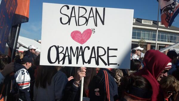 Nick Saban loves ObamaCARE! (Auburn fans hold sign about Alabama Coach) 