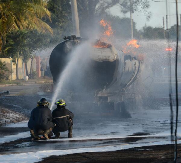 JamaicaGleaner's tweet image. Acc. to tanker driver first explosion happened at 3:30 p.m.. Here fire fighters work to extinguish fire (via @rmakyn)