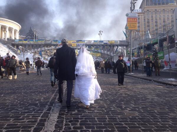 Newlyweds in Independence Square as smoke blows over the barricades. #kiev #euromaidan