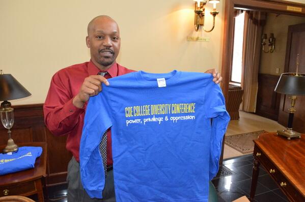 Coordinator of Multicultural Affairs Steven Shelby displays T-shirt for participants at Coe Diversity Conference.