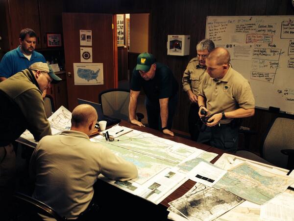DrewPetrimoulx's tweet image. Forestry officials plotting maps in search for missing pilot. Visibility poor, terrain wet. #missingpilot #ARnews