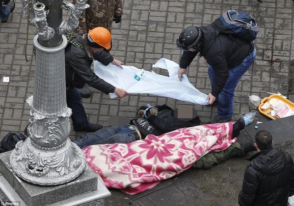 Protesters covering one of the bodies in Independence Square, Kiev, this morning. Photo: <a href="/Reuters/">Reuters</a>