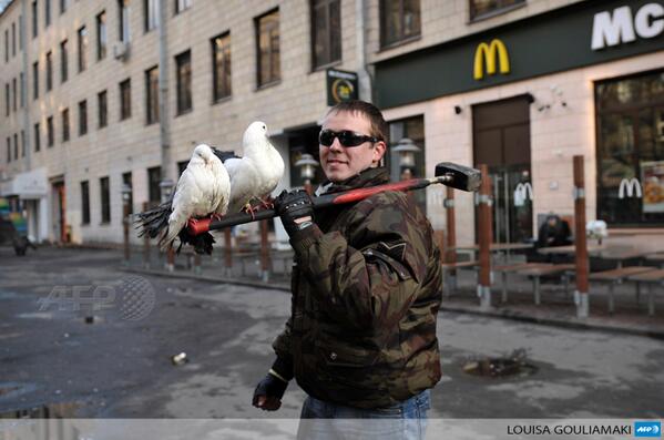 afpfr's tweet image. PHOTO - Un manifestant porte des colombes sur un marteau à  Kiev,  en Ukraine