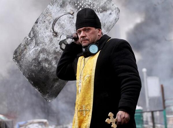 LibeMonde's tweet image. Un prêtre orthodoxe bouclier au poing (Photo Sergey Gapon. AFP) #Kiev #Ukraine