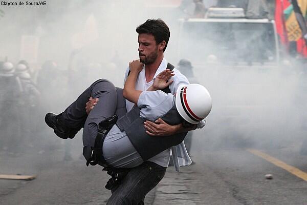 Protestor carries out injured riot police officer out of the danger zone during the 2013 protests in #Brazil.