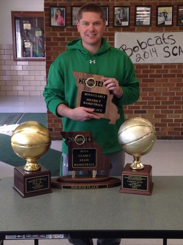 Coach Matt Pitts displays SCA, District, Liberty , and State trophies for a great basketball season   Record 27-5